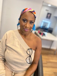 a woman sitting in a chair wearing a colorful headband